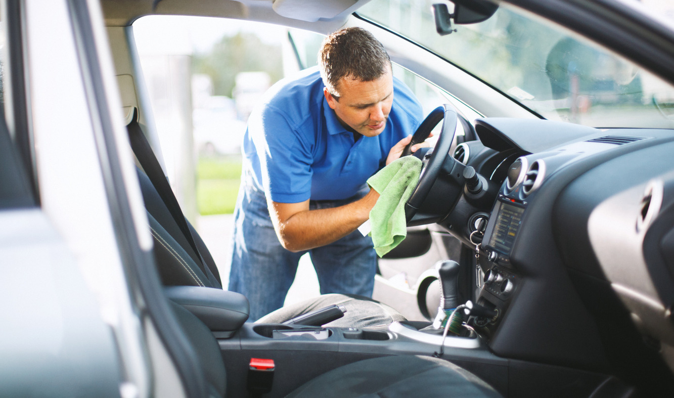 A man maintaining his own car at his home garage